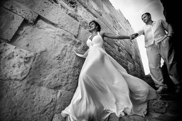 Il vento soffia vestito della sposa mentre lei scende con uno sposo — Foto Stock