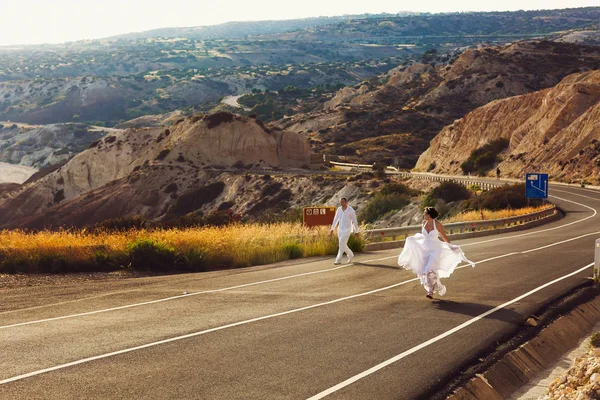 Щаслива весільна пара гуляє по шосе — стокове фото