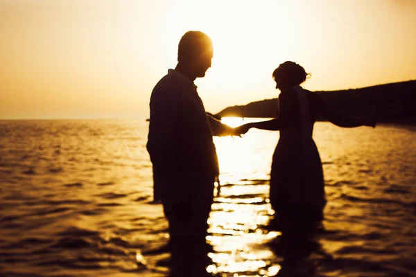 Silhouetten van een paar houden elkaar handen en permanent — Stockfoto