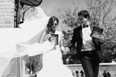 Yeni evliler ellerinde küçük simgeler ch dışarı yürümeye tutun.