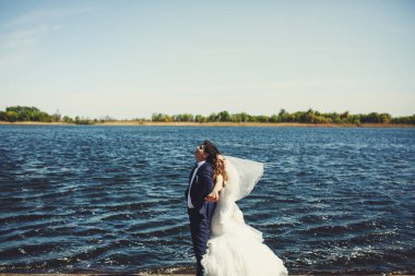 Gelin peçe Rüzgar darbeler uzakta iken o damadın geri eğilir 