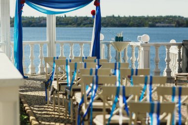 Beig sandalye mavi clo yapılan düğün sunak önünde stand