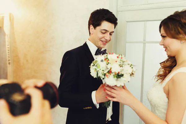 O noivo dá à noiva um buquê de casamento terno — Fotografia de Stock