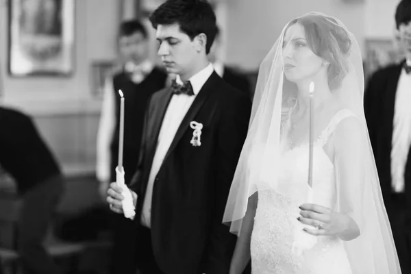 Mariée tient une bougie debout dans une église — Photo