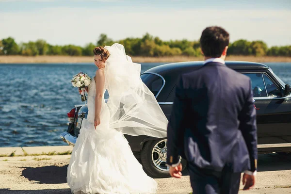 Sposa guarda oltre la spalla su uno sposo in piedi dietro un vecchio — Foto Stock