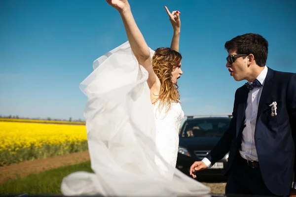 花嫁は黄色の後ろに新郎で立っている彼女の手を発生させます。 — ストック写真