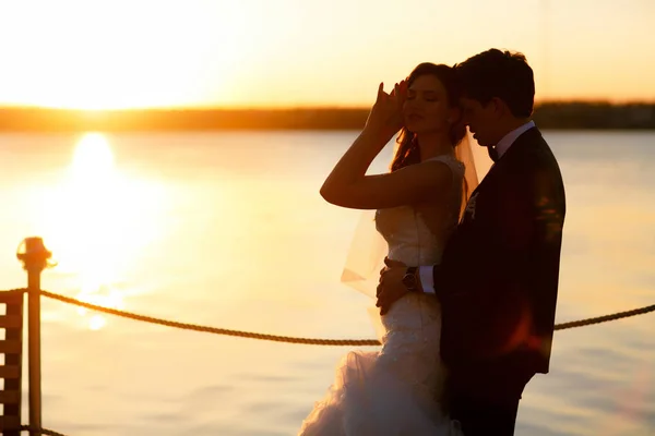 Der Bräutigam lehnt sich von hinten an eine Braut, die vor einem — Stockfoto