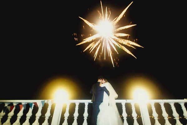 Yeni evliler öpüşme üzerinde havai fişek parıldıyor — Stok fotoğraf