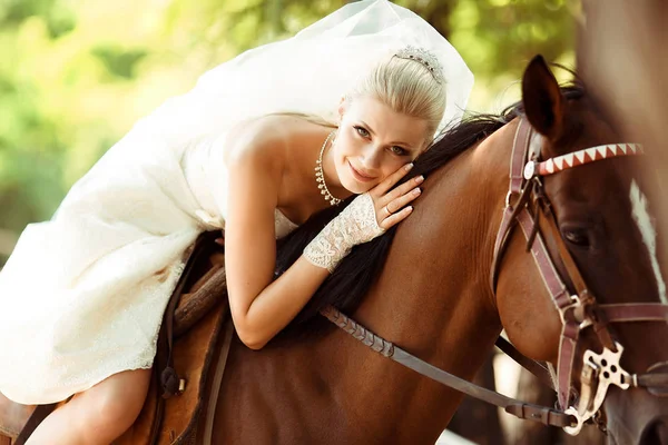 Στο νυφικό φόρεμα η όμορφη νύφη βόλτες ένα άλογο — Φωτογραφία Αρχείου