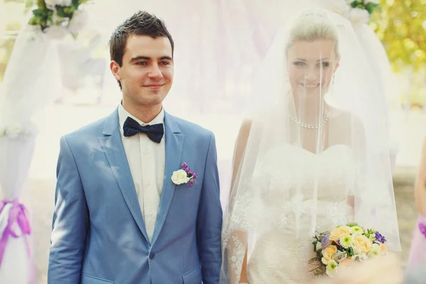 Bonito noivo e noiva coberto com um véu — Fotografia de Stock