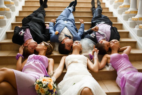 Novia y novio con los amigos en las escaleras — Foto de Stock