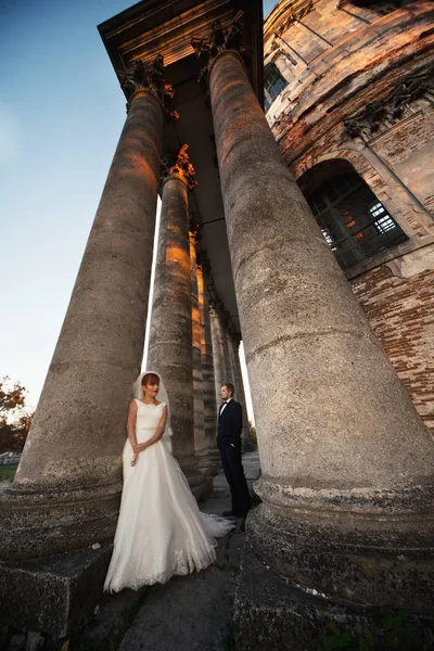 Прекрасная влюбленная пара стоит рядом с колоумами — стоковое фото