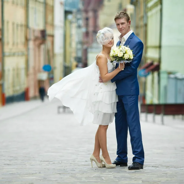 Vento soffia abito corto della sposa via mentre lei sta dietro un gr — Foto Stock