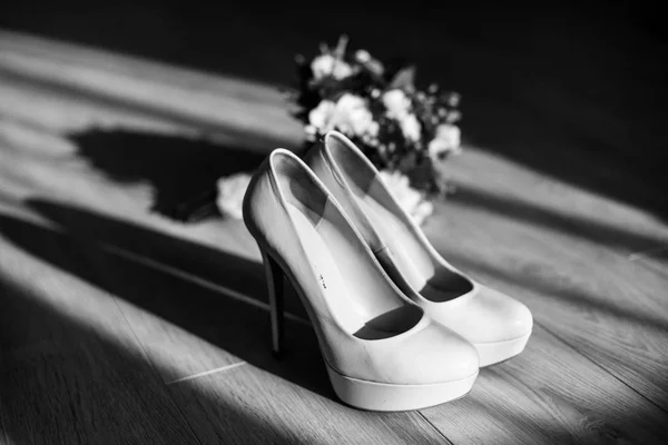 The wedding bouquet stands near shoes — Stock Photo, Image