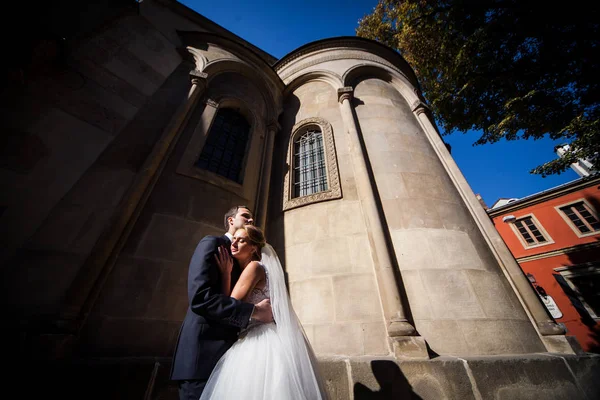 O casal apaixonado abraçando perto do edifício — Fotografia de Stock