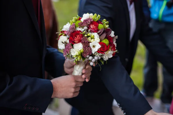 De bruidegom houdt een bruiloft boeket — Stockfoto