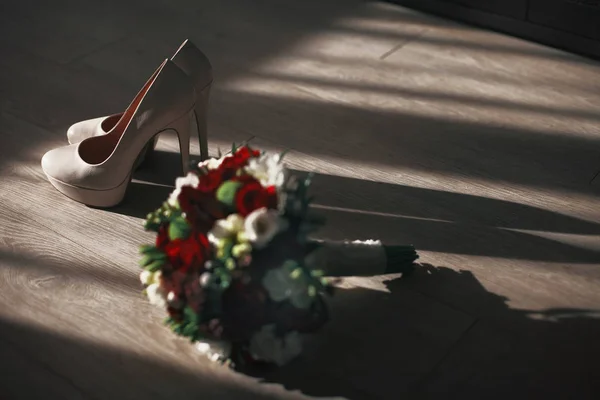 The wedding bouquet stands near shoes — Stock Photo, Image