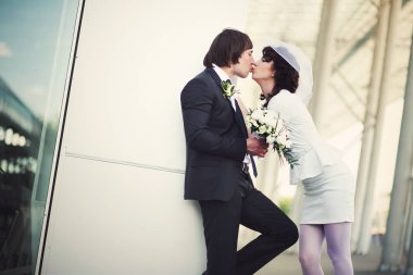 O beyaz için eğilir iken gelin elbise kısa bir damat öper. 