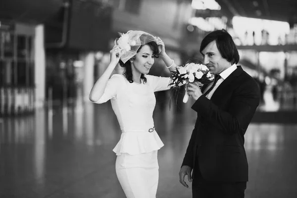 Groom smells a wedding bouquet standing behind a bride in the ai — Stock Photo, Image