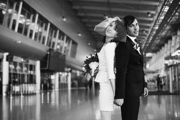 Mariée et marié se tiennent dos à dos dans le hall de l'aéroport — Photo