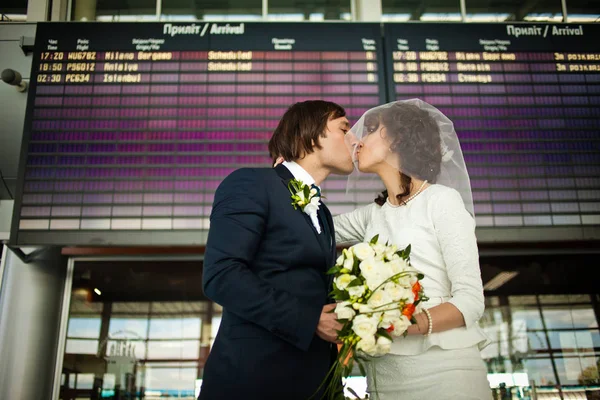 Стильний весільний пара поцілунок, поки вони стоять під інформацією — стокове фото