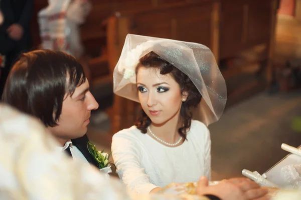 Mooie bruid kijkt naar een bruidegom met liefde die haar hand op de — Stockfoto