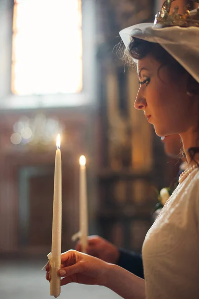 Nevěsta vypadá zamyšleně na svíčku světlo během angažmá ce — Stock fotografie