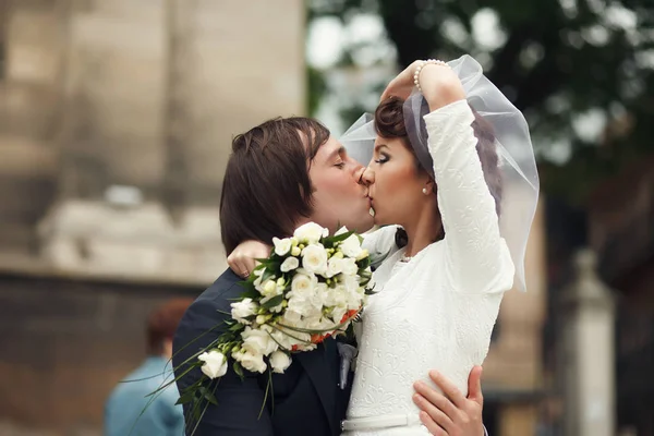 Brudgummen lutar sig själv en nådig brud kysser henne — Stockfoto