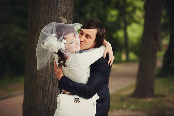Happy groom embraces a bride in short veil — Stock Photo, Image