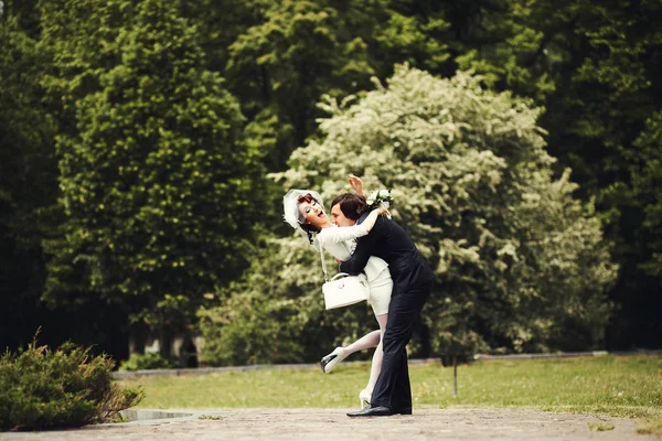 Image drôle d'un marié caressant mariée dans le parc — Photo