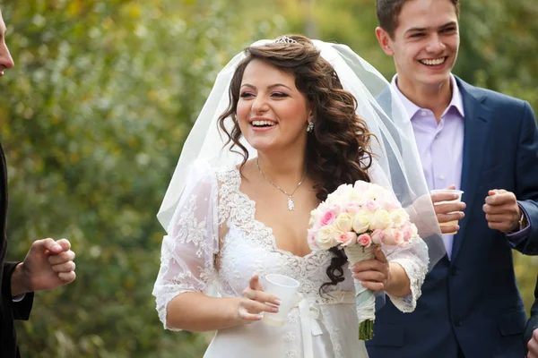 Feliz novia sonríe a los invitados de pie fuera — Foto de Stock