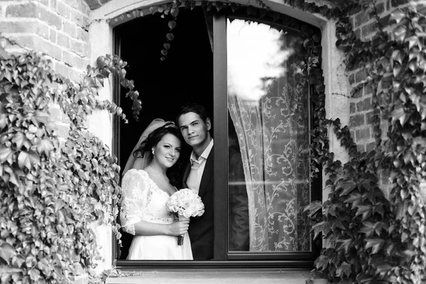 Foto em preto e branco de recém-casados deslumbrantes sorrindo enquanto eles — Fotografia de Stock