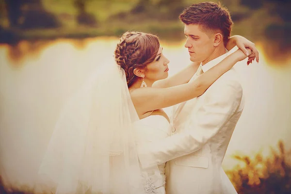 結婚式のカップルを湖でポーズの温かみのある色調の画像 — ストック写真