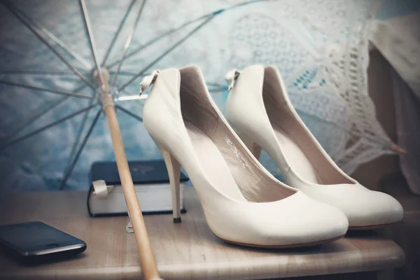 Vita skor står under vit spets paraply — Stockfoto