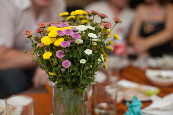 Gelbe, violette und weiße Feldblumen stehen in einer Vase auf dem — Stockfoto