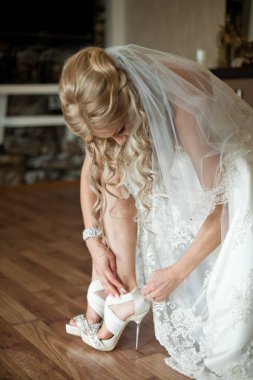 Sarışın gelin önü açık düğün ayakkabıları ayarlar 