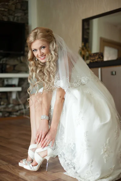 Braut lächelt aufrichtig, während sie ihre Schuhe anpasst — Stockfoto