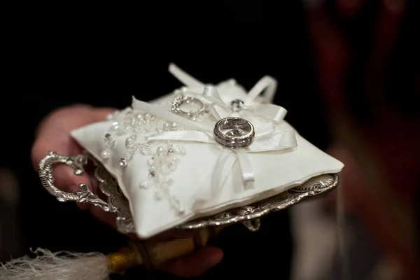 Travesseiro branco decorado com pérolas e contas encontra-se na prata — Fotografia de Stock