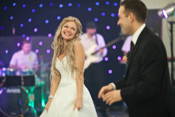 Blonde bruid kijkt verlegen staan achter een bruidegom in de dance hall — Stockfoto