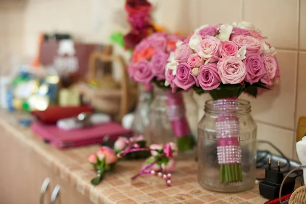 Rosa Hochzeitsstrauß steht in der Flasche auf dem Küchentisch — Stockfoto