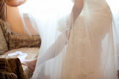 Gelin gelinlik üzerinde kadın çorabı koyar