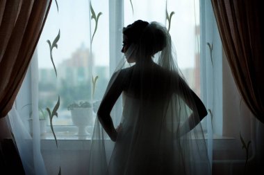 Bir pencere önünde poz bir gelin silüeti