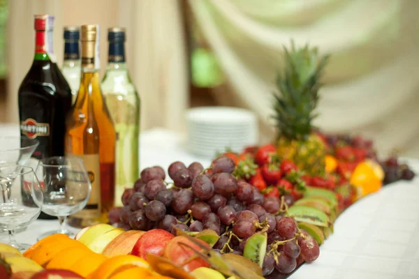 Smaczne winogrona leżą na lustra tacy pełen owoców — Zdjęcie stockowe