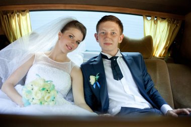 Gelin ve damat arka koltukta otururken gülümse