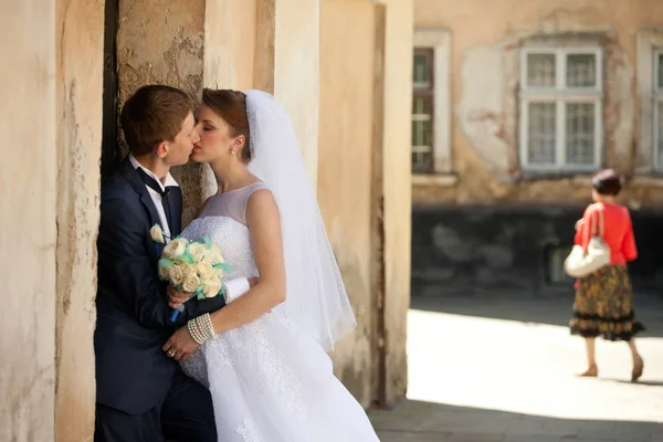 古い壁の後ろに隠れている新郎新婦のキス — ストック写真