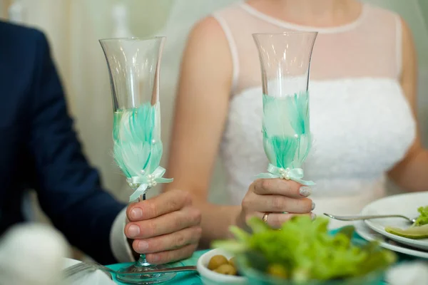 Menyasszony és a vőlegény tartsa pezsgõspohárnaks díszített feathe menta — Stock Fotó