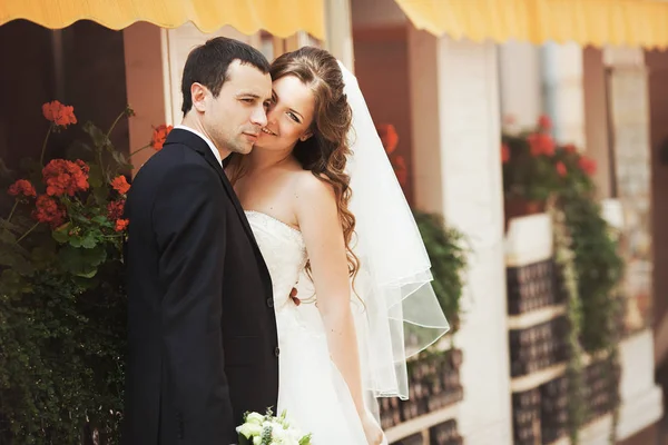 Groom regarde loin tenant une mariée souriante dans ses mains — Photo