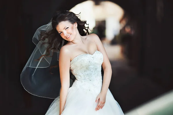 Невеста с длинными вьющимися волосами позирует в лучах солнца — стоковое фото