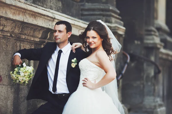 Sposa si appoggia su un serio sposo in piedi sulla vecchia strada — Foto Stock