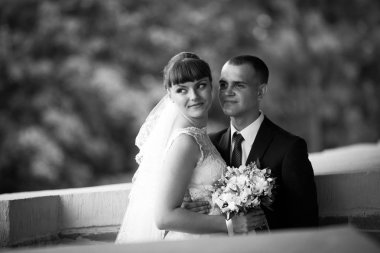 Uzakta damadın hugs tuğla balco üzerinde duran gelin görünüyor